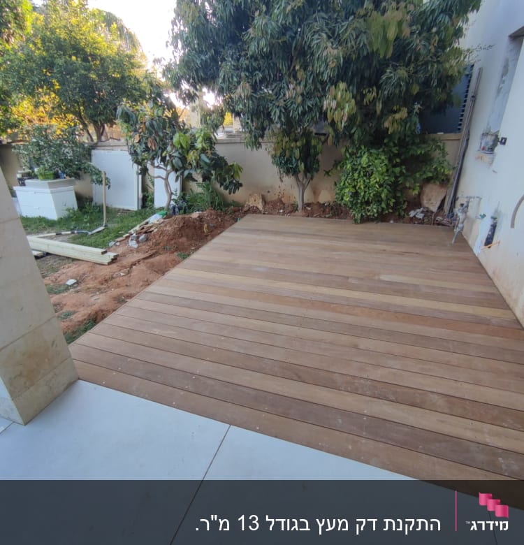 דק עץ בגינה עם עצים מסביב